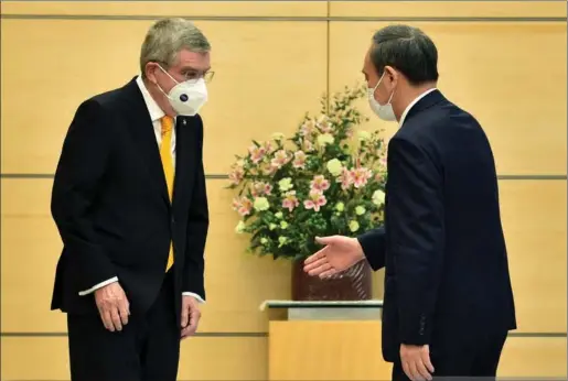  ?? PIC: KAZUHIRO NOGI / AFP) (PHOTO BY KAZUHIRO NOGI/AFP VIA GETTY IMAGES ?? IOC president Thomas Bach meets Japanese prime minister Yoshihide Suga in Tokyo on Wednesday.