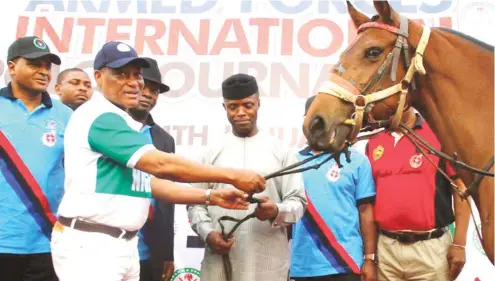  ??  ?? Defence Minister Mansur Dan-Ali presents a Polo pony to Vice President Yemi Osinbajo (middle) at the recently concluded Armed Forces Internatio­nal Polo Tournament in Abuja