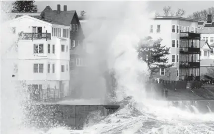  ?? Michael Dwyer, The Associated Press ?? A large wave crashes into a seawall in Winthrop, Mass., on Saturday, a day after a nor’easter pounded the Atlantic coast. Officials in eastern Massachuse­tts warned of another round of flooding during high tides.