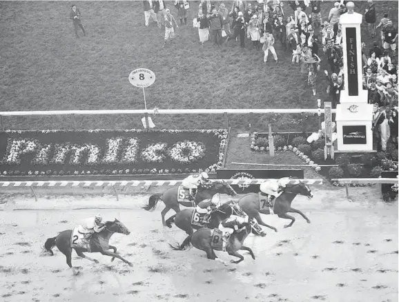  ?? JOSHUA MCKERROW/BALTIMORE SUN MEDIA GROUP ?? Justify crosses the finish line to win the 143rd Preakness at Pimlico by a half length over second-place Bravazo, which made a late charge. Tenfold held on to place third.