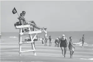  ??  ?? Lifeguards watch over Bethany Beach, Del., in June. They’ve been trained to work wearing masks and gloves when possible. JENNA MILLER/ DELAWARE NEWS JOURNAL