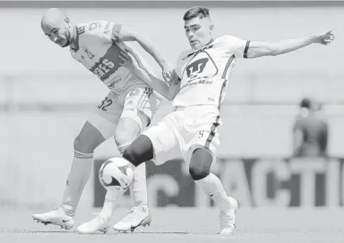  ?? FOTO: JAM MEDIA ?? > Carlos “Cocoliso” González de Tigres y Johan Vázquez de Pumas en disputa por el balón.