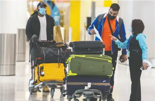  ?? PETER J THOMPSON / NATIONAL POST ?? Travellers arrive at Pearson Internatio­nal Airport and are guided to hotels for mandatory quarantine stays of three days. Some travellers are avoiding quarantine and could face hefty fines, public health officials say.