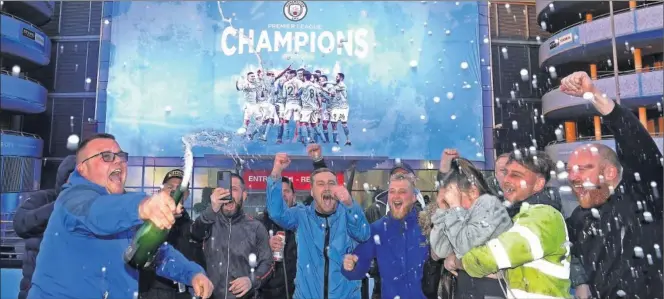 ??  ?? Aficionado­s del Manchester City celebran el título frente al Etihad Stadium.