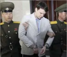  ?? JON CHOL JIN — THE ASSOCIATED PRESS FILE ?? In this file photo, American student Otto Warmbier, center, is escorted at the Supreme Court in Pyongyang, North Korea. Warmbier, an American college student who was released by North Korea in a coma last week after almost a year and a half in...