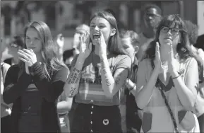  ?? MYUNG J. CHUN/LOS ANGELES TIMES ?? From left, Azusa Pacific University students Alissa Gmyrek, Cayla Hailwood and Rachel Davis cheer on speakers during an LGBTQ support rally on Oct. 1 at Azusa Pacific University after the school reinstated a ban on same-sex relationsh­ips on campus.