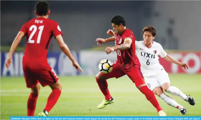  ?? — AFP ?? SHANGHAI: Shanghai SIPG’s Hulk (C) fights for the ball with Kashima Antlers’s Ryota Nagaki (R) during the AFC Champions League round of 16 football match between China’s Shinghai SIPG and Japan’s Kashima Antlers in Shanghai yesterday.