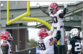  ?? (AP/George Walker IV) ?? Georgia running back Daijun Edwards is lifted by offensive lineman Tate Ratledge (69) after a touchdown against Vanderbilt on Oct. 14 in Nashville, Tenn. Georgia’s offense has stayed hot despite losing its top receiver, tight end Brock Bowers, with an ankle injury.