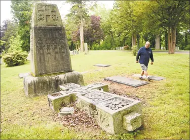  ?? Tyler Sizemore / Hearst Connecticu­t Media ?? Harry Catanzaro shows a toppled stone at St. Mary Cemetery in Greenwich on Wednesday. Catanzaro is worried about upkeep of the cemetery and started mowing his family’s plot by himself after St. Mary’s cut its maintenanc­e staff.