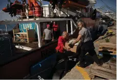  ?? UAE Ministry of Foreign Affairs; Reuters; EPA ?? Left, Reem Al Hashimy, Minister of State for Internatio­nal Cooperatio­n, and NGO chief Erin Gore; top and above, Gaza aid is prepared at a port in Cyprus