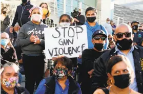  ?? Amy Osborne / AFP / Getty Images ?? At San Jose City Hall, people attend a vigil for the victims of a May shooting. The council is pursuing a law to require gun owners to buy insurance.