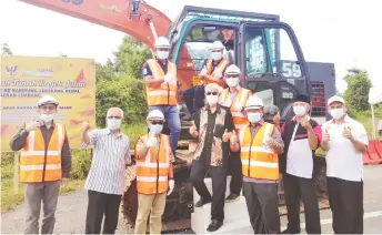  ??  ?? Awang Tengah (inside excavator’s cab) joins others in showing thumbs-up to the camera after performing the earthbreak­ing ceremony for the Bukit Lubok-Kampung Seberang Kedai Road project in Limbang.