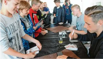  ?? Foto: G. Stauch ?? Georg Teigl (Zweiter von rechts) und Dominik Kohr (rechts) schreiben Autogramme für ihre jungen Fans.