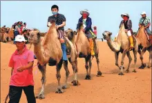  ?? GE JUN / FOR CHINA DAILY ?? Tourists ride camels in the Kubuqi Desert.