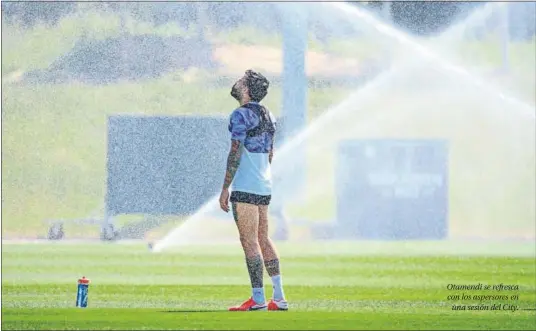  ??  ?? Otamendi se refresca con los aspersores en
una sesión del City.