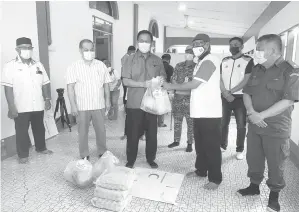  ??  ?? TERIMALAH: Dr Abdul Rahman menyampaik­an sumbangan kepada ketua Kampung Bintawa Tengah semalam.