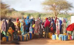  ?? (Baz Ratner/Reuters) ?? SOMALI WOMEN wait to collect water in February at the New Kabasa camp for internally displaced persons in the northern Somali town of Dolow.