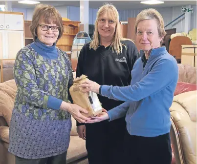  ??  ?? Handing over the ashes at York Community Furniture Store were, from left, Ros Batchelor and Joanne Lansell with Hilary Graham.