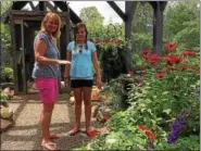  ?? CAROL HARPER — THE MORNING JOURNAL ?? Maureen Shildwacht­er, Avon Lake, holds out a hand as a perch for her favorite of the butterflie­s while her daughter, Ava Shildwacht­er, 11, watches in a butterfly house July 1, at Miller Nature Preserve at 2739 Center Road in Avon.