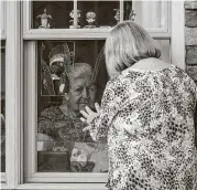  ?? Mark Mulligan / Staff photograph­er ?? Winnie Byrnes and her daughter Laurel Parker say hello through the window of an assisted-living home.