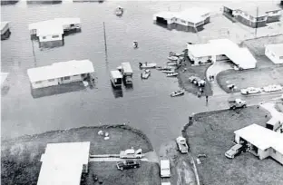  ?? COURTESY ORANGE COUNTY REGIONAL HISTORY CENTER ?? A 1960 photograph shows houses and vehicles underwater after flooding in Orange County. Regional flood controls can quickly absorb 2 or 3 inches but would likely be overwhelme­d by a storm like Harvey.