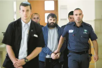  ?? MAHMOUD ILLEAN/AP 2016 ?? Yosef Haim Ben David, center, arrives at court in Jerusalem during his trial in the death of a Palestinia­n boy. An Israeli group raising funds for convicted Jewish radicals, including Ben David, is collecting donations in the U.S.