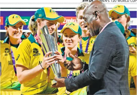  ?? AFP ?? A fourth title: Meg Lanning, the captain of Australia, receives the trophy from Sir Vivian Richards at the end of the ICC Women’s World T20 final cricket match against England in Antigua on November 24.