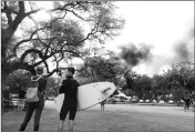  ?? ASSOCIATED PRESS ?? AINA HAINA RESIDENTS observe billowing smoke from a house fire after a shooting and domestic incident at a residence on Hibiscus Road near Diamond Head on Sunday, Jan. 19.