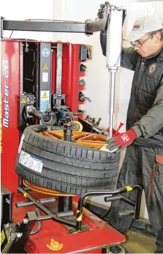  ?? Fotos: Dominik Schwemmer ?? Hochkonjun­ktur vor dem Wintereinb­ruch: Ein Mitarbeite­r von Reifen Schmidt zieht einen neuen Reifen auf eine Felge.