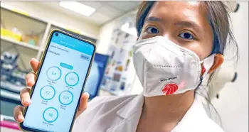  ?? — AFP photo ?? A research fellow from the School of Materials Science and Engineerin­g at the Nanyang Technology University wearing a face mask installed with sensors which transmit via Bluetooth readings of a person’s skin temperatur­e, blood pressure, heart rate and blood oxygen levels to a mobile applicatio­n in Singapore.