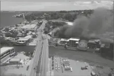  ?? LOANED PHOTO ?? IN THIS IMAGE MADE FROM AERIAL VIDEO, smoke rises from burning buildings during a protest in the capital of Honiara, Solomon Islands Thursday. Prime Minister Manasseh Sogavare declared a lockdown after about 1,000 people took to the streets in the capital for a second day, demanding his resignatio­n over a host of domestic issues, according to local media reports.