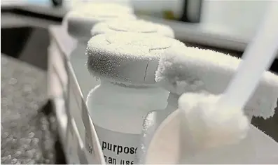  ?? Pictures: DEEPA KESA ?? CHILLED: Mock vaccine bottles show how cold they get in the Cryo-vacc mobile freezer, which is opened by Renergen CEO Stefano Marani, top right.