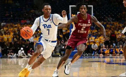  ?? Justin Berl/Getty Images ?? Pitt’s Bub Carrington dribbles against Florida State’s Jamir Watkins in the first half March 5 at Petersen Events Center. Carrington was named to the All-ACC Rookie team on Monday.