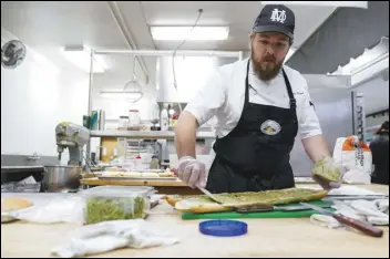  ?? ASSOCIATED PRESS ?? Chef Josh Gjersand prepares a sandwich for Mount Diablo High School students to try during a taste test in Concord, Calif. The suburban San Francisco district has been part of a national “farm-to-school” movement for years, where schools try to buy as much locally as possible.