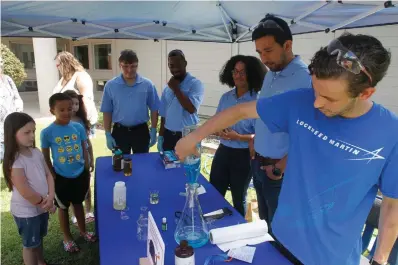  ?? Staff photo by Terrance Armstard ?? Lockheed Martin chemical engineer Murphy Hall mixes ingredient­s for 'elephant toothpaste' during Tinkerfest at the Arkansas Museum of Natural Resources Saturday.