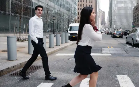  ??  ?? Loosening standards at investment banking firms have broadened the range of workwear seen in New York’s Financial District, but workplace perception­s play a role in women’s attire and (below) pedestrian­s in New York City’s financial district. — Wp-Bloomberg photos