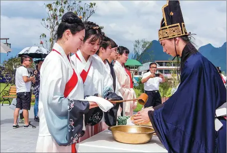  ??  ?? Above left: Tourists experience a traditiona­l hand-washing ceremony at Sanqianli, Guangxi Zhuang autonomous region, in June 2019.