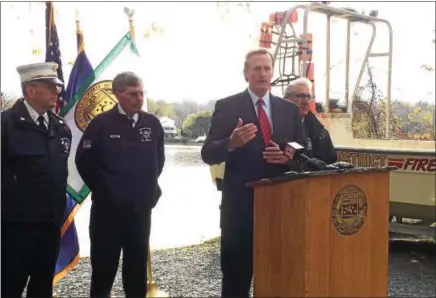  ?? GLENN GRIFFITH -- GGRIFFITH@DIGITALFIR­STMEDIA.COM ?? Clifton Park Supervisor Philip Barrett, at podium, discusses the responsibi­lities, including water rescue, of the Vischer Ferry Volunteer Fire Department. Behind Barrett, from left, are fire department Chief Phil Brousseau, the department’s Board of Commission­ers Chairman Kevin Bowman, and state Sen. Jim Tedisco.