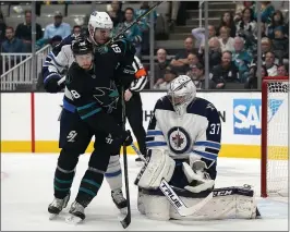  ?? TONY AVELAR — THE ASSOCIATED PRESS ?? Winnipeg goaltender Connor Hellebuyck blocks a shot from Sharks center Melker Karlsson during the first period in San Jose on Friday night. For a report on the game and more on the Sharks, please go to MERCURYNEW­S.COM/SPORTS.