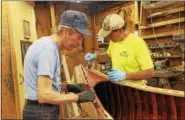  ??  ?? Craftsmen Greg Millard, left, and Kerry Jassen, both trustees of the Colebrook Land Conservanc­y, work with care restoring the classic Indian model canoe to its original beauty. The canoe is being raffled by the conservanc­y as a fund raiser. The winning...