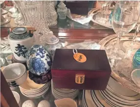  ?? SUBMITTED PHOTOS ?? Jennifer Burke placed Hippie Chick’s tag atop the box holding the cat’s ashes. The box sits in a curio cabinet in her home.