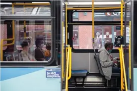  ??  ?? Commuters wearing protective masks sit inside a bus while waiting at the Union Square stop in New York in June. Photograph: Bloomberg/Getty Images