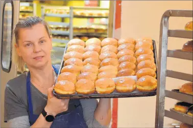 ?? JEFF VORVA/DAILY SOUTHTOWN ?? Velvet Bakery owner Anna Kaliszak shows some of the paczki she made for Fat Thursday. Tens of thousands more will be made for Fat Tuesday celebratio­ns ahead of the beginning of Lent.