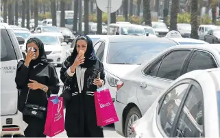  ?? Photo /AFP ?? New market: Saudi women walk amid vehicles at a street in the Saudi Arabian capital, Riyadh, on Thursday. The decision to allow women to drive has lit up social media, with cheers and jeers for the ruling, which will take effect in June 2018.