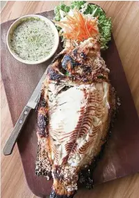  ??  ?? The salt-grilled tilapia features very fresh fish with tender, flaky meat and a lovely salty shell.