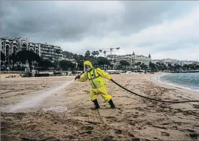  ?? VALERY HACHE / AFP ?? Feines de desinfecci­ó a la platja de Canes