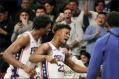  ?? MARK LENNIHAN — THE ASSOCIATED PRESS ?? The 76ers’ Joel Embiid, left, congratula­tes teammate Jimmy Butler, center, after Butler sank a 3-pointer Sunday night to give the 76ers a 127-125 come-from-behind victory over the Nets in Brooklyn.