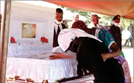  ?? Photo: Elizabeth Hiyolwa ?? Rest easy… Benedickus Johannes Nkundu’s widow Anna Nkundu bids farewell to her late husband, while accompanie­d by family members.