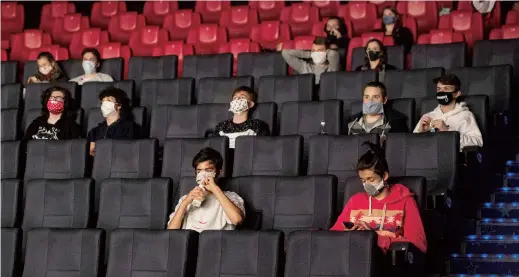  ??  ?? People wearing face masks in a Prague movie theater as shopping malls, restaurant­s with outdoor seating, hairdresse­rs and other businesses slowly reopen after a two-month pause in Czech Republic. — AFP