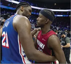  ?? CHRIS SZAGOLA — THE ASSOCIATED PRESS ?? Joel Embiid, left, talks with former teammate Jimmy Butler following Wednesday’s play-in tournament game at the Wells Fargo Center.The 76ers won, 105-104.